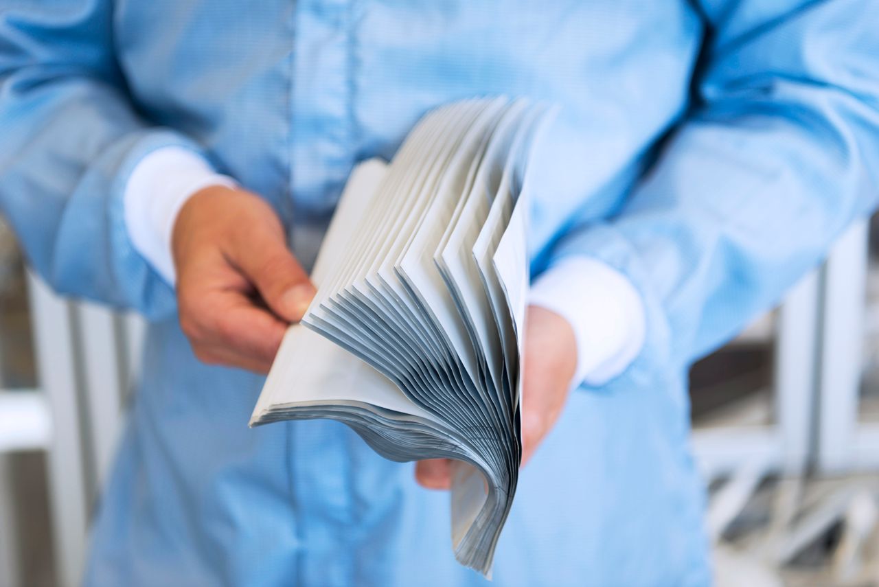 Hands flipping through a booklet.