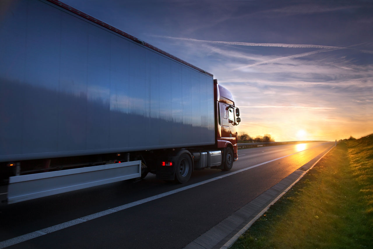 Truck driving towards the sunset.